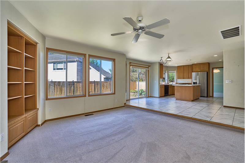Family Room View with Built-In Shelves, Ceiling Fan. View looking into the Breakfast Nook and Kitchen.