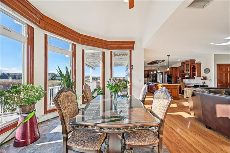 Sunroom eating area with kitchen beyond