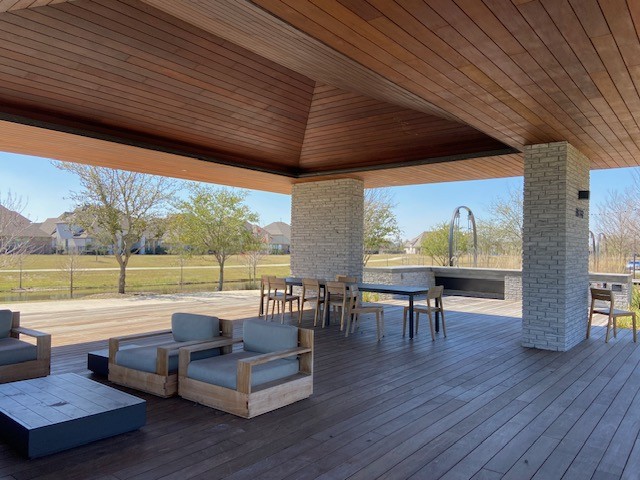 Community area with outdoor kitchen and seating by the trails near this home.