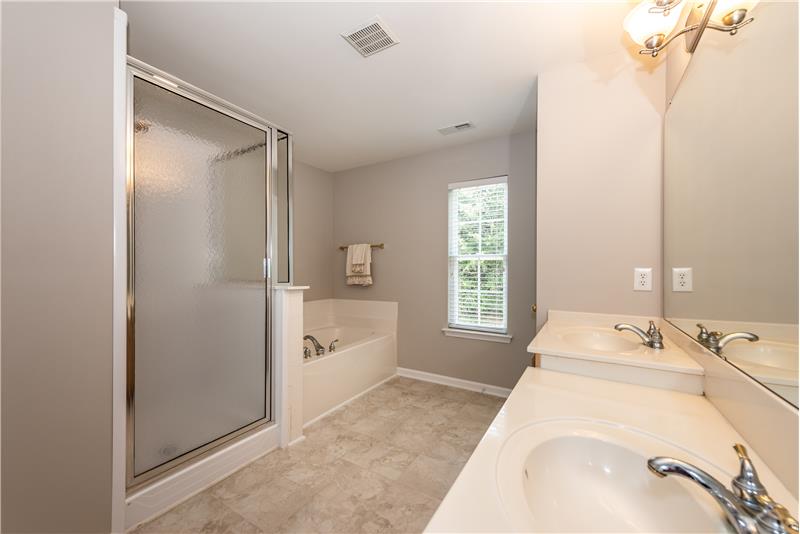 Owner's en-suite bathroom: soaking tub, step-in shower, double sink vanity, updated light fixture, private water closet.