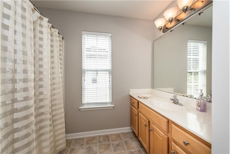 Hall bath shared by second floor bedrooms with expanded vanity, updated light fixture, tub/shower.