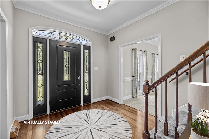 Center-hall foyer with beautiful front door with leaded glass accents.
