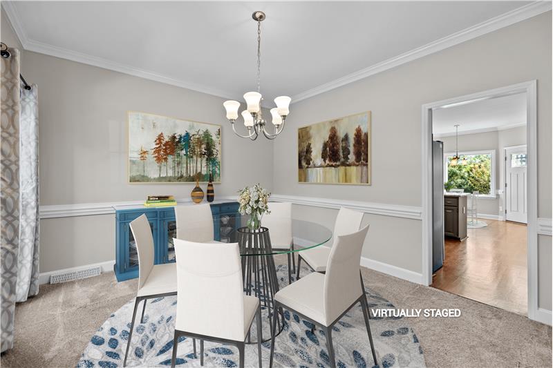 Formal dining room features crown molding, chair rail, neutral decor.