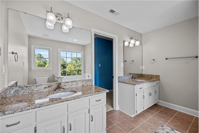 Owner's bathroom has double vanities with granite, tile floors, updated light fixtures.