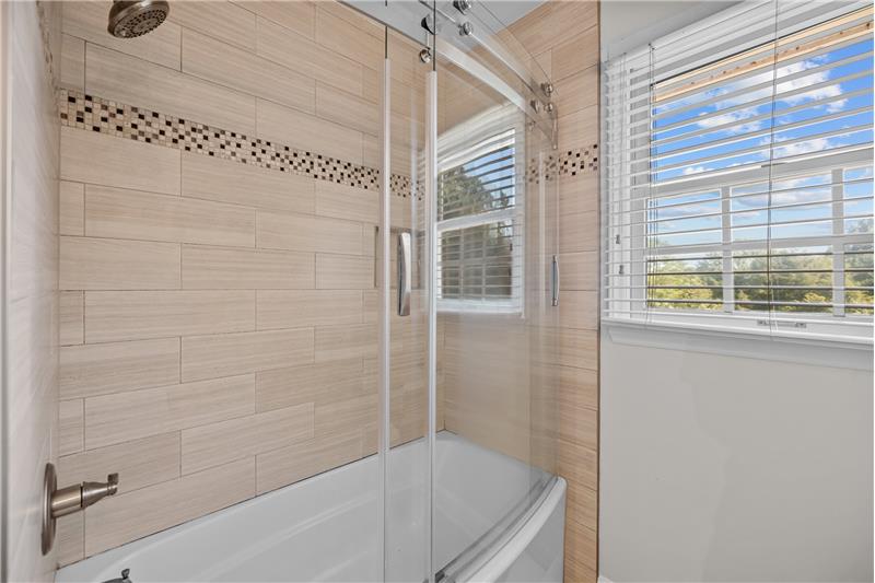 Full bath updated in 2017 includes tile surround and frameless tub/shower door.