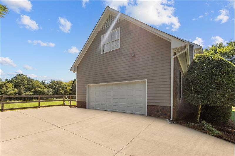 2-car side load garage features wide driveway for additional parking and garage door keypad entry.
