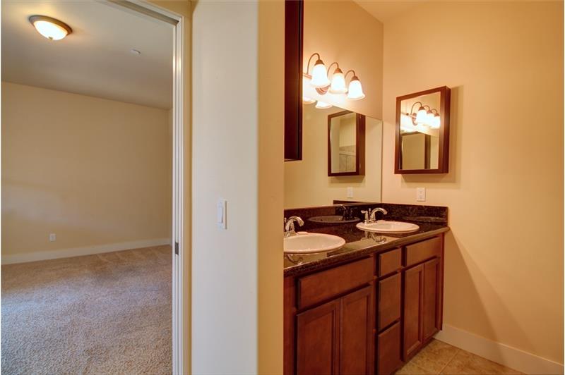 En suite Master Bath vanity with granite counter tops, dual sinks, ample wood cabinetry and great lighting!