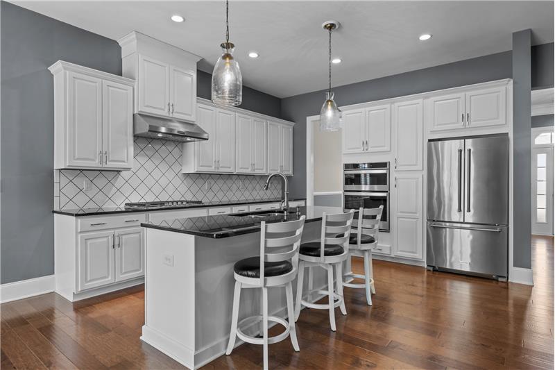 Kitchen: features raised panel cabinets with crowns, granite counters, stainless steel appliances, custom tile backsplash.