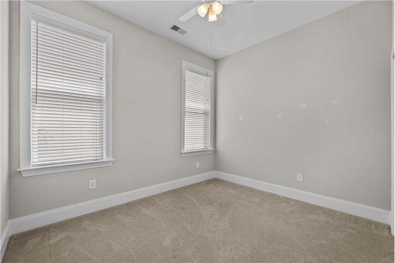 Secondary Bedroom #2: features neutral paint, neutral carpet, ceiling fan with light, faux wood blinds.