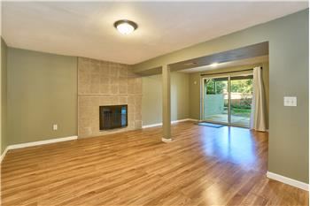Huge Downstairs Recreational Room with Hardwood Laminate Flooring and Tile Surround Wood Burning Fireplace.