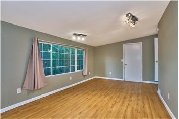 Another View of the Converted Garage into a Bedroom with Laminate Flooring and Newer Light Fixtures.