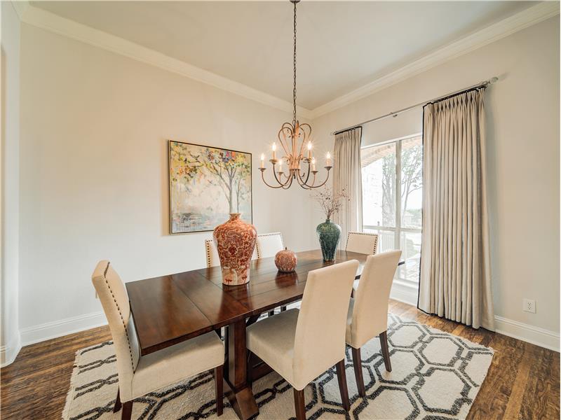 Dining area with a chandelier, ornamental molding, and dark hardwood / wood-style flooring