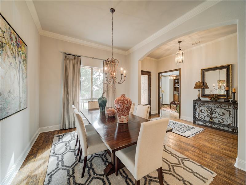 Dining area with dark hardwood / wood-style flooring, a notable chandelier, and ornamental molding