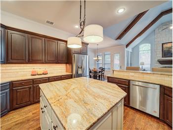 Appliances with stainless steel finishes, light hardwood / wood-style flooring, a kitchen island, hanging light fixtures