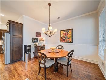 Breakfast nook space with ornamental molding, light hardwood / wood-style floors, and a chandelier
