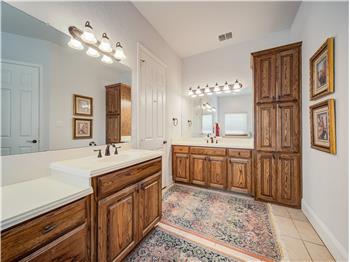 Primary bathroom featuring tile flooring and dual bowl vanity