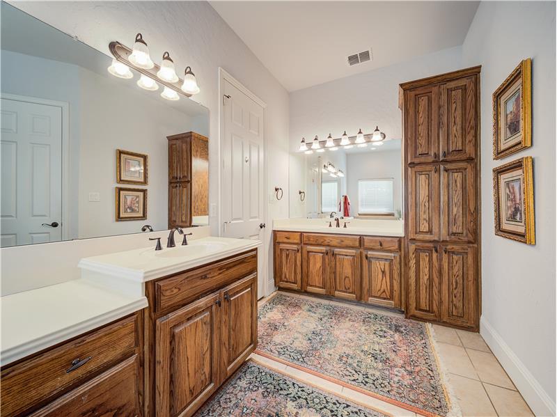 Primary bathroom featuring tile flooring and dual bowl vanity