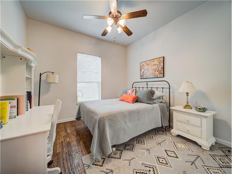 Downstairs bedroom with hard wood flooring, large closet, ceiling fan and high ceiling