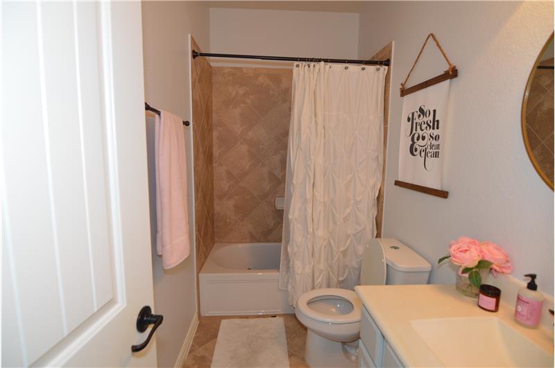 Full bathroom with shower/tub combination adjacent to second downstairs bedroom.