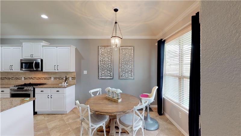 Welcoming breakfast area with updated light fixture and access to covered patio and backyard!