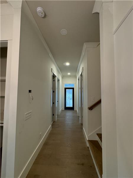 Hallway to two downstairs bedrooms and bonus upstairs.