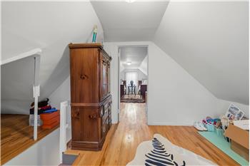 Vaulted ceilings, hardwood flooring, and built-in white railings