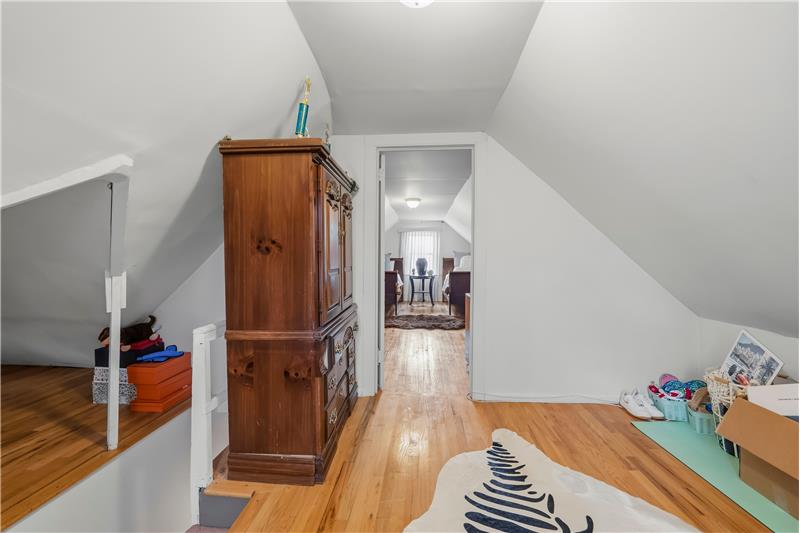 Vaulted ceilings, hardwood flooring, and built-in white railings