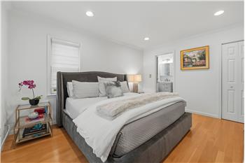 Primary bedroom suite with ample closets, Wood-finish flooring, recessed lighting, crown molding