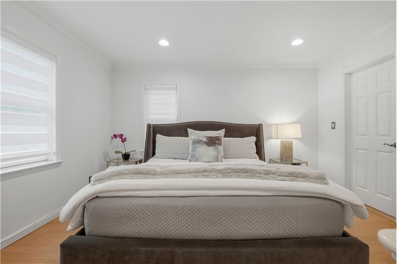 The oversized primary suite, with its cathedral ceiling-its own full bath, offers a private retreat  a quiet haven