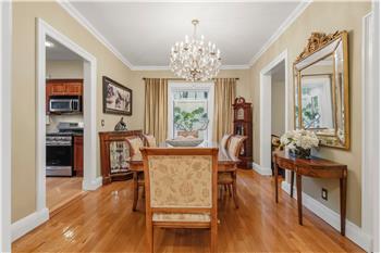 Dining area featuring wood-finish flooring, crown molding, and a crystal chandelier