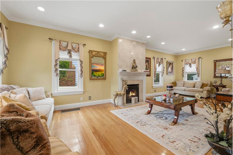 Open interior featuring wood-finish flooring, recessed lighting, crown molding, and a staircase with a wooden banister