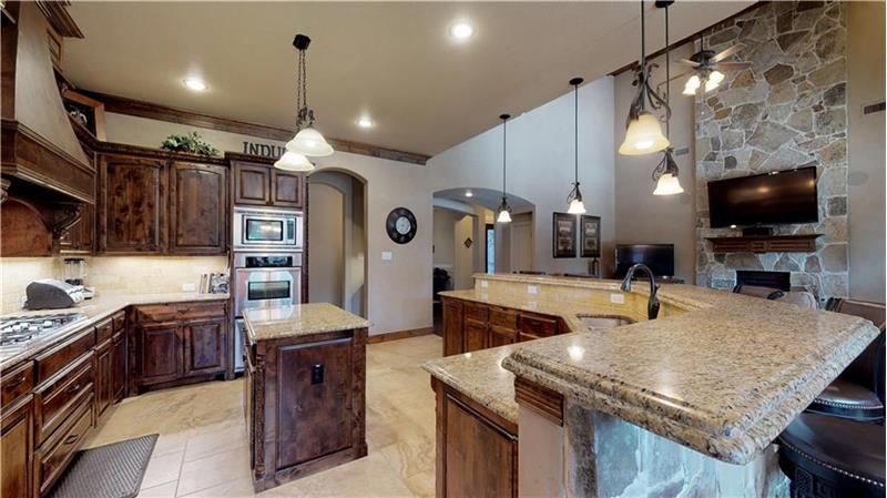 Can you believe this kitchen?! Double ovens, island, pot filler, gas cooktop, and plenty of bar seating