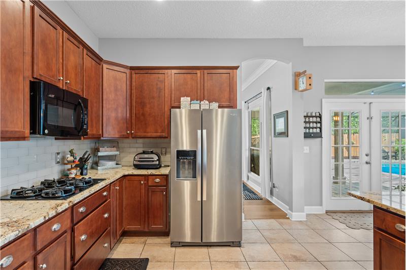 Granite Countertops, gas cooktop, double ovens, custom tile flooring, breakfast bar overlooking the Family Room