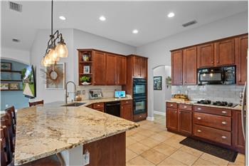 Granite Countertops, gas cooktop, double ovens, custom tile flooring, breakfast bar overlooking the Family Room