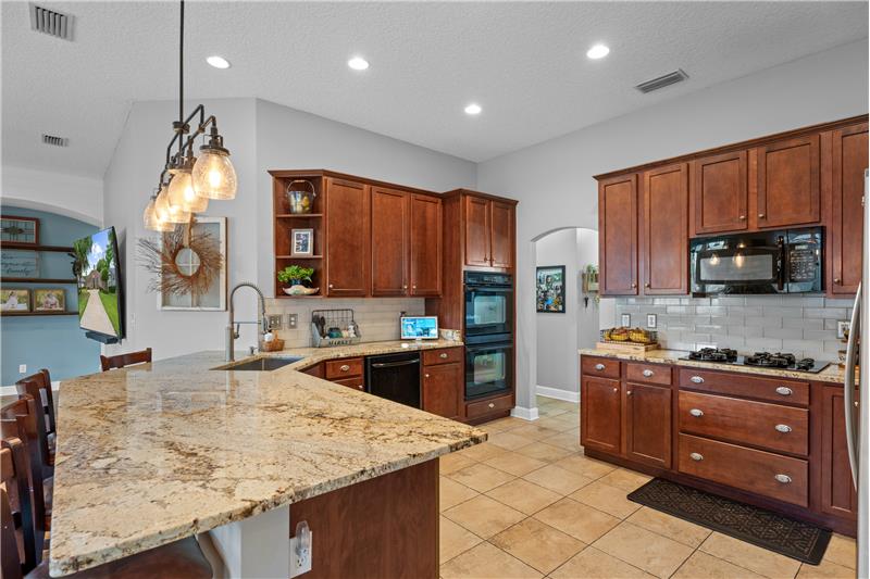 Granite Countertops, gas cooktop, double ovens, custom tile flooring, breakfast bar overlooking the Family Room
