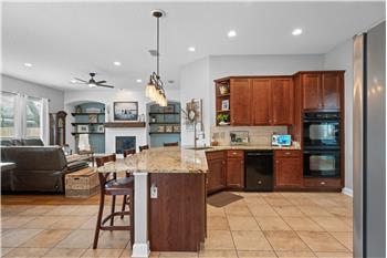 Granite Countertops, gas cooktop, double ovens, custom tile flooring, breakfast bar overlooking the Family Room
