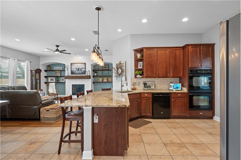 Granite Countertops, gas cooktop, double ovens, custom tile flooring, breakfast bar overlooking the Family Room