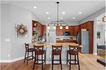 Granite Countertops, gas cooktop, double ovens, custom tile flooring, breakfast bar overlooking the Family Room