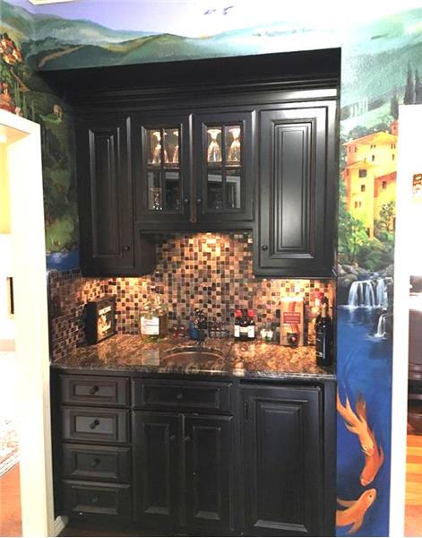 wet bar with trompe-l'oeil painting on wall