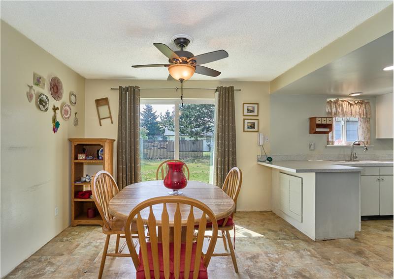 Dining Room with Ceiling Fan and Slider to the Backyard and Patio.