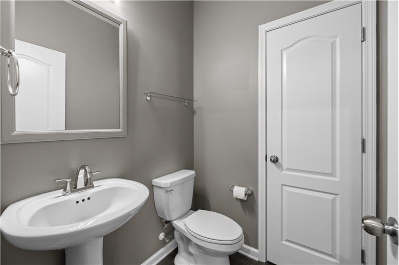 Main level powder room with neutral tones. clean design, linen closet