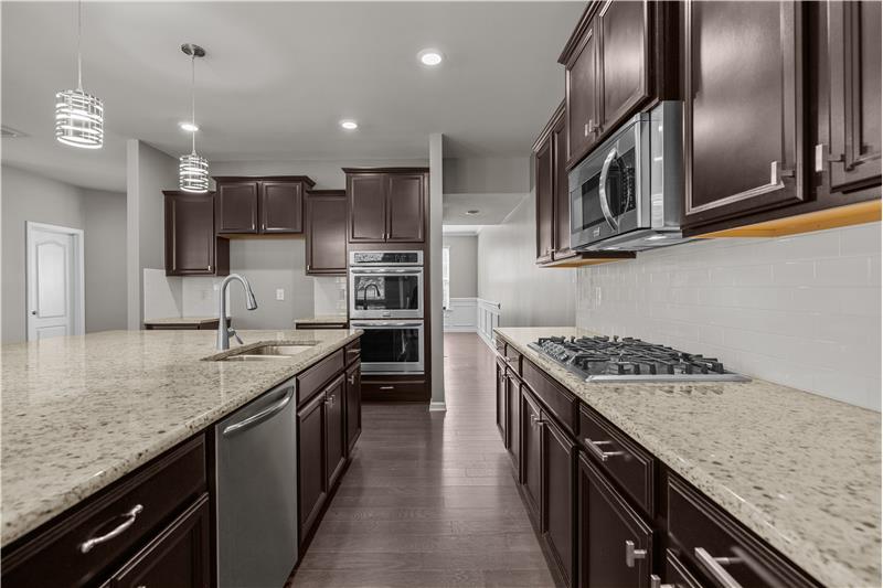 An entertainer’s dream kitchen with oversized island, granite counters, and seamless connection to the great room