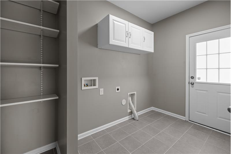 Well-appointed laundry room with ample storage, room for large washer/dryer, and exterior access