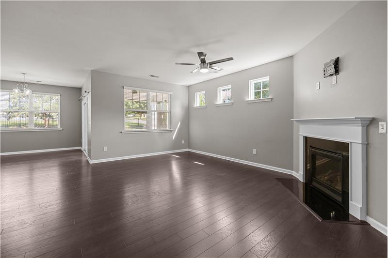 Great room features a gas fireplace, windows for natural light, open flow to the dining area