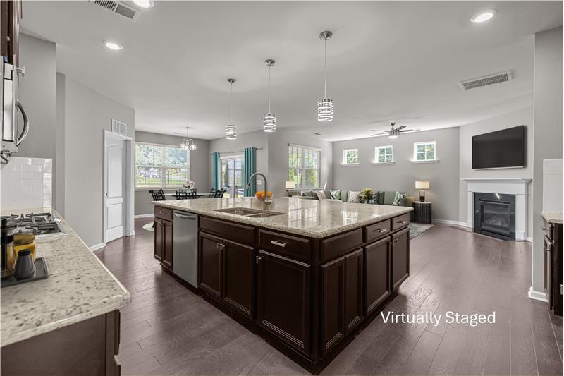 Open-concept kitchen with over-sized island, sleek granite countertops, ample cabinet storage