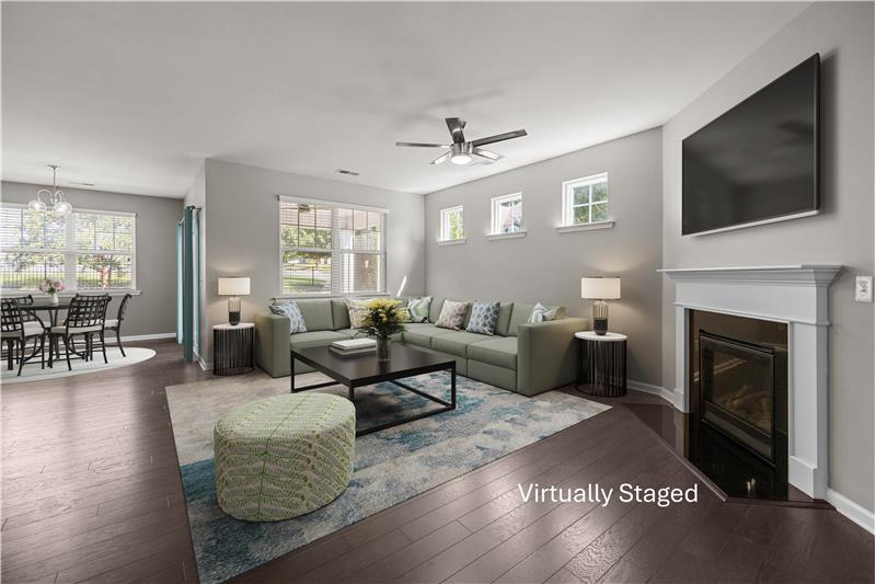 great room designed for entertaining, complete with abundant windows, warm flooring, and a welcoming open layout