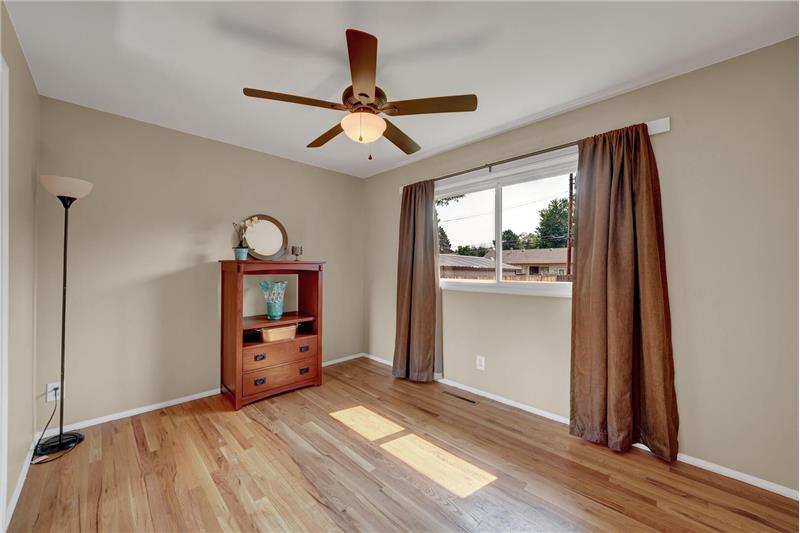 The main level Master Bedroom boasts wood floors and a lighted ceiling fan 