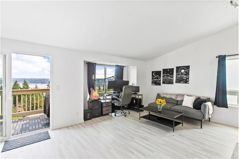 The living room features vaulted ceilings and the windows let in so much natural light.