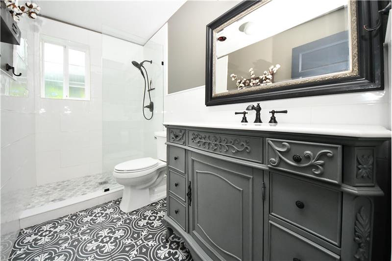 Downstairs bathroom with porcelain/marble/handmade Italian tile. Custom 1920's style sink cabinet.