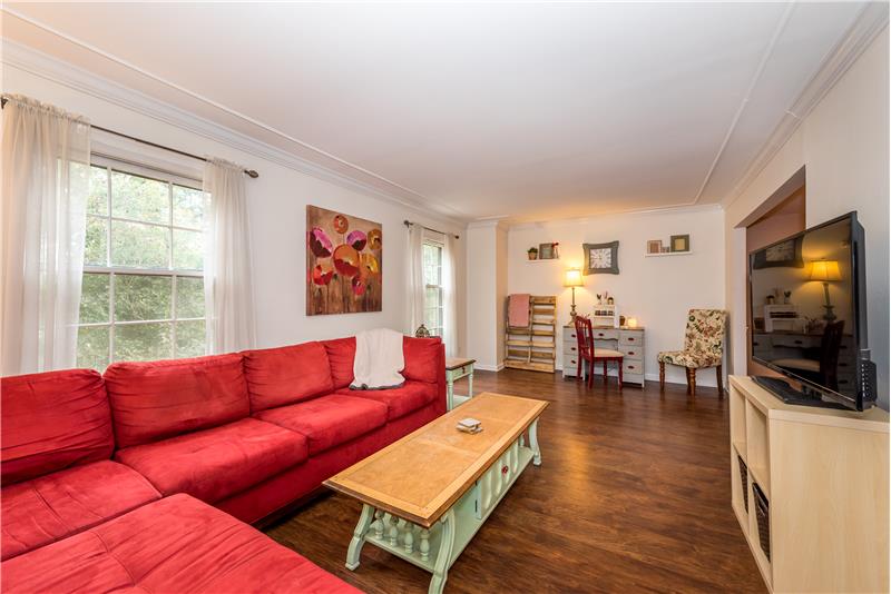 Living room features gleaming floors, crown molding details.